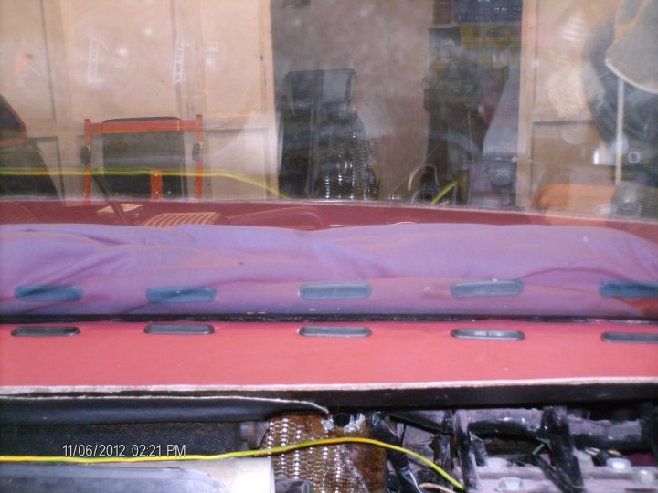 400se restoration part 2 - Page 3 - Wedges - PistonHeads - The image shows a closed lid of a laptop computer with a purple, checkered surface texture. Beneath the lid, wires, screws, and various electronic components are visible, suggesting maintenance or replacement is being performed. A partial view of what appears to be a character or sign can be seen in the reflection of the glass door, though the actual content of the reflection is unclear. The photograph has a timestamp in one corner indicating the date and time it was taken. The style of the image suggests it was taken candidly, perhaps in a public space or a store window.