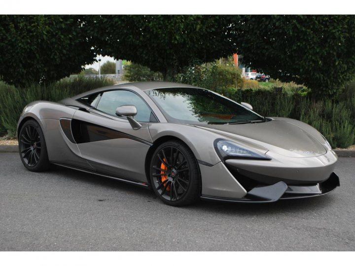 New toy - Page 1 - McLaren - PistonHeads - The image shows a sporty gray composite car with a sleek design, featuring black accents and silver rims. The car is a two-door convertible, characterized by a long and low hood, and has a prominent front grill and aerodynamic body lines.