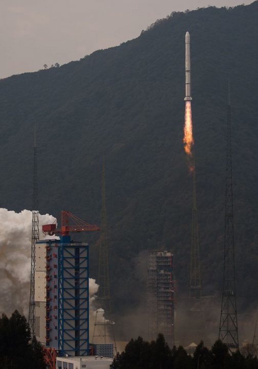 Pistonheads - The image presents a moment of scientific achievement and power, featuring a white rocket launched into the sky. The rocket, adorned with flames at its base, is ascending steeply sloping terrain. In the foreground, silhouettes of industrial structures, possibly spacecraft or launch facilities, are visible against a mountainside backdrop. Surrounding vegetation and the company's name on the foreground structures indicate the location in China. This scene captures the essence of human progress in space exploration.