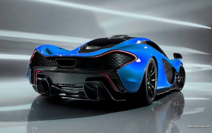 RE: McLaren P1 revealed - Page 4 - General Gassing - PistonHeads - The image features a futuristic sports car with a sleek blue exterior on display, exhibiting dynamic lines and aerodynamic curves. The car appears to have a convertible top, indicating it could be a convertible model. It is situated in a studio setting with a mirror image visible, reflecting the single car in a symmetrical fashion. In the bottom right corner, there is a watermark with the text "NetCarsShow.com", possibly indicating the source of the image or the company affiliated with the car.