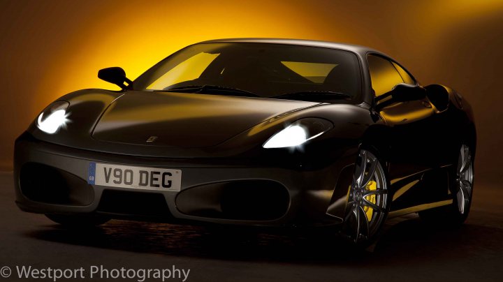 Why are there so few car photographs? - Page 10 - Photography & Video - PistonHeads - The image captures a sleek, black sports car in sharp focus against an intense yellow background. The car's design is contemporary with a clean, smooth body, and it features the bright alloy wheels that typical sports cars have. The camera angle is slightly from the front left, and the light that's reflecting on the car's side highlights the vehicle's well-maintained surface. The car is parked, and the image doesn't contain any people or additional vehicles.