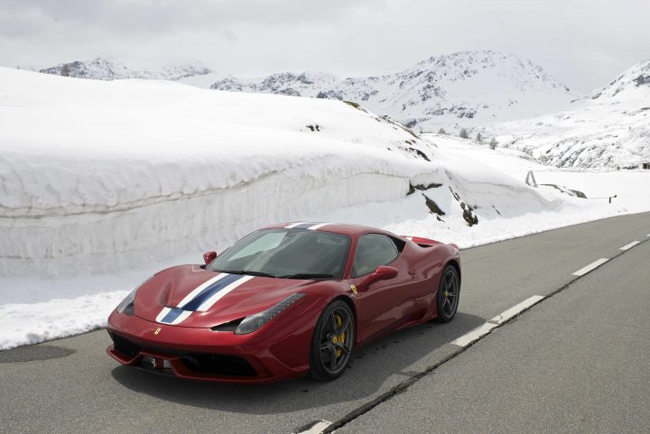 Ferrari Speciale Factory Collection (and comparison to CS an - Page 1 - Ferrari V8 - PistonHeads - The image shows a red sports car with a white and blue color scheme on the roof and hood on a snowy road. The car is positioned at an angle to the camera, emphasizing its sleek design and the direction it is facing. The natural landscape in the background features snow-covered hills and the photo is taken under an overcast sky. There are no visible texts or people in the vicinity, and the focus is on the car and its interaction with the wintry setting.