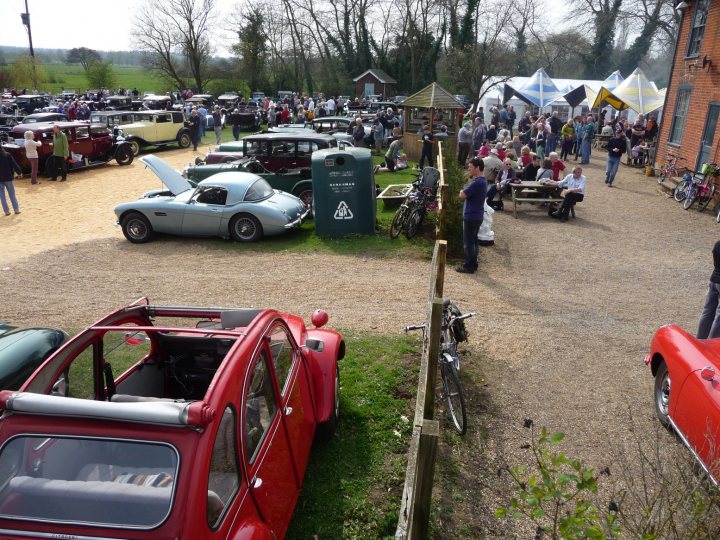 Bentley Pistonheads Boys Showtime - The image captures a lively scene of a large auto show held in a field. The field is filled with a diverse array of vintage cars, carefully parked and displayed for the onlookers. Amongst the crowd of people, two individuals stand out, engaged in conversation, standing between the vehicles. The atmosphere seems vibrant and engaging, with people inspecting the cars and enjoying the exhibition. The setting suggests a day dedicated to showcasing these classic vehicles, bringing together enthusiasts and spectators alike.