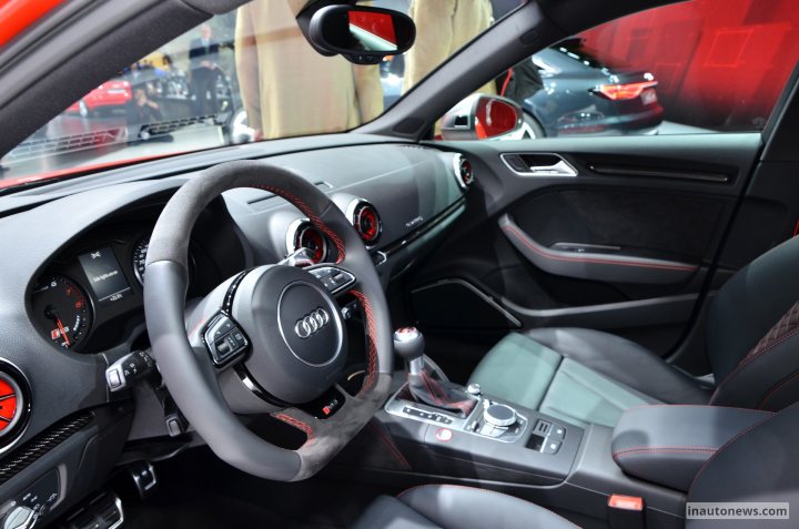 RE: Audi RS3 pricing confirmed - Page 18 - General Gassing - PistonHeads - The image showcases the interior of a car, focusing on the dashboard and driver's seat area. The dashboard features an Audi brand design and is adorned with black leather upholstery, punctuated by inlaid red stitching that adds a striking contrast. The driver's seat is centrally placed, providing a clear view of the steering wheel, which is equipped with a manual gear shift. The car's instrument cluster, made of timeless and high-quality material, is a prominent feature on the dashboard. The steering wheel, along with the gear shift and various buttons visible on the dashboard, hint at the luxury and comfort the car offers.