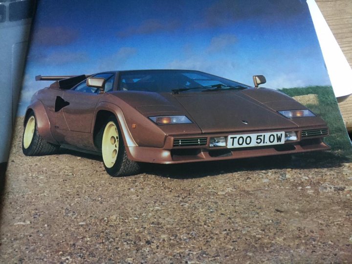 My old Lambo photos from the 90s - Page 25 - Lamborghini Classics - PistonHeads - The image portrays a luxurious, two-door sports car from the 1990s, possibly resembling a Lamborghini Diablo. It's situated on a dirt ground with a rocky surface, adding a rugged contrast to the sleek vehicle. The car's reg plates read "Too 510W," indicating it might be a modified or customized vehicle. The sky forms the backdrop, with blue hues suggesting a sunny day. The overall composition of the image suggests a dynamic and adventurous lifestyle associated with such high-performance vehicles.