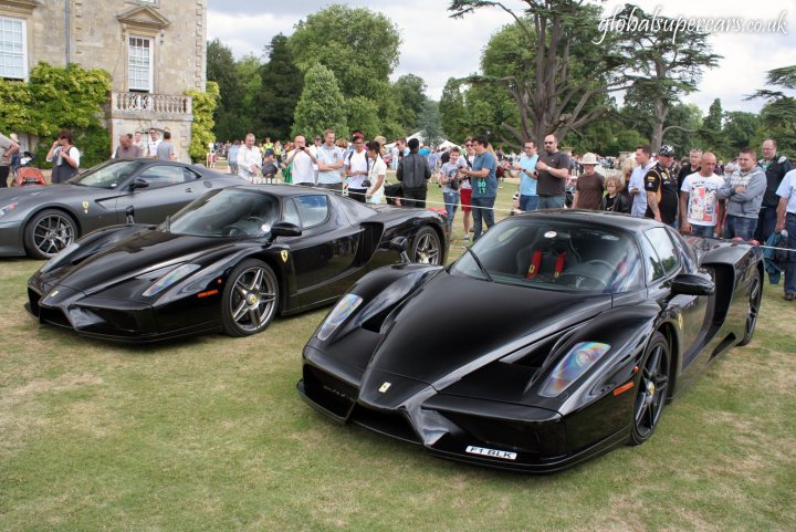 A group of motorcycles parked next to each other - Pistonheads - The image showcases three sports cars on display at an outdoor event. The cars are sleek and black, likely designed for speed and performance. They are parked on grass, perhaps for a car show or exhibition. The surrounding area is populated with onlookers, their attention captivated by the showcased vehicles. The setting seems to be a fair or exhibition, with multiple people milling about, some carrying handbags and others standing still to admire the cars.