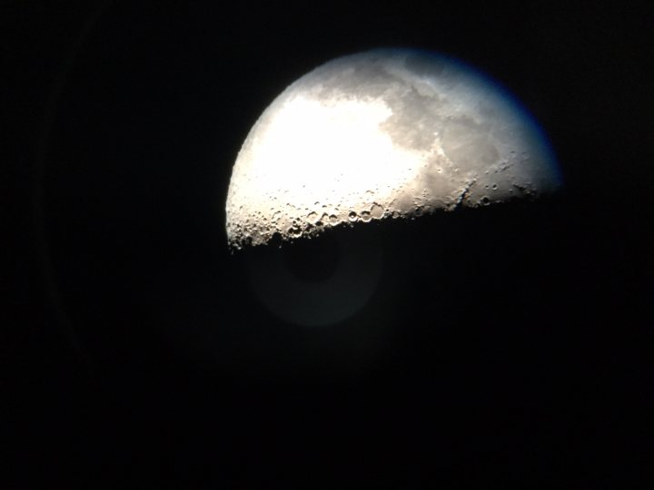 Webcam Astrophotography  - Page 1 - Science! - PistonHeads - The image captures a stunning view of a full moon set against a dark night sky. The moon's surface is visible, showing its cratered face under the glow of sunlight. The moon is located centrally in the frame and is the brightest object in the image. The contrast between the moon and the surrounding darkness emphasizes the moon's prominence in the celestial scene. The perspective of the photo suggests it may have been taken from ground level, looking up at the moon.