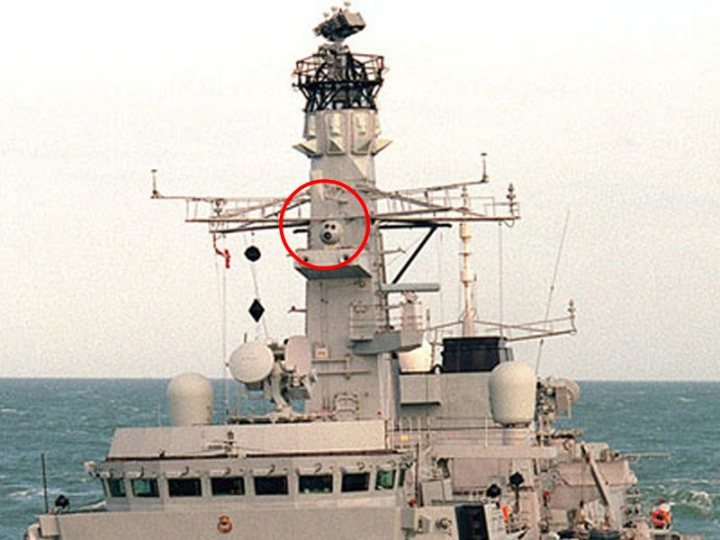 Pistonheads - The image depicts a multi-level gray ship, visible against a slightly cloudy sky. The ship appears to be well-equipped, with structures on the superstructure that suggest advanced technology. Notably, a circular item, possibly a camera or sensor of some kind, is located near the center of the ship. The ocean swells around the ship, suggesting motion or turbulence in the sea. The image is a bit blurred, indicating it may have been taken at some distance or with a lower quality camera.