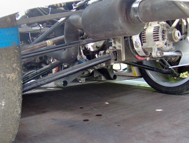 Bhp Loads Pistonheads - This image captures a scene under a car hood, revealing the mechanical aspect of automotive engineering. The primary focus is an internal combustion engine, seen through a gap in the engine cover. The engine features a coiled rubber belt wrapped around several pulleys, guiding the movement of various engine components. The metallic interface with the mounting frame above suggests this assembly's structural integrity, ensuring the engine's secure and efficient operation within the car's chassis. There are no external factors or altering components visible in the immediate vicinity, with a clear line of sight leading directly to the engine and its associated components.