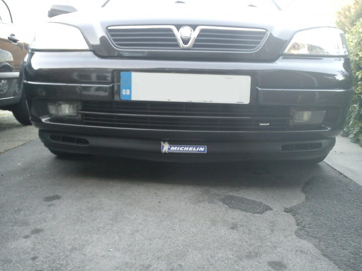 Running with MAF unplugged, bad idea? - Page 1 - Engines & Drivetrain - PistonHeads - The image showcases the front section of a black Vauxhall car. The vehicle is parked on a gray tarmac, indicating it may be the parking lot or the street. The car's licence plate is white and reads "GB 12", suggesting it is registered in the United Kingdom, as indicated by the "GB" prefix. On the bumper of the car, there is a small, blue, and white logo, which is likely the manufacturer's logo, indicating that the car was manufactured by Vauxhall.