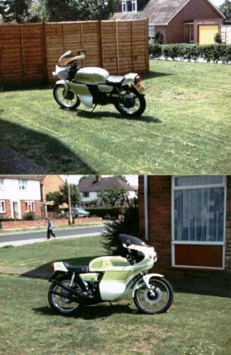 Suzuki 500 2 stroke Cafe Racer - Page 3 - Biker Banter - PistonHeads - The image depicts a motorcycle parked in an outdoor area, likely near a residence. It is a composite of two separate pictures placed side by side. In the left image, the motorcycle is positioned in front of a wooden fence and grass. In the right image, the motorcycle is parked next to a house with a brick exterior and a white window frame. The motorcycle has a vintage design, hinting at a possible era or a specific model preference. The juxtaposition of the two images suggests a comparison or contrast between the two locations where the motorcycle is seen parked.