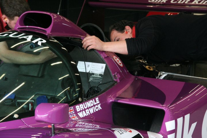 A man is riding a motorcycle in the street - Pistonheads - In the dimly lit garage, a mechanic is hunched over the cockpit of a vibrant purple race car. He is meticulously inspecting or adjusting the shield, possibly the driver's visor, of the car. The hood of the car is open, revealing its intricate mechanical components. The word "RACE" is visible on a nearby work station, underscoring the setting's purpose and intensity.