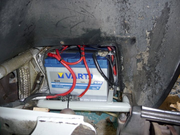 A bicycle is parked next to a suitcase - Pistonheads - The image offers a close-up of an automotive part, where a blue and gray car battery is situated, presumably compressed like a squash in a vehicle's engine area. The battery is connected by red cables, with the brand "VART" indicated on it. Surrounding the battery, one can observe metallic surfaces and components, possibly hinting at the complex operating environment of a car. The car is likely in the process of maintenance or repair, and this image captures a moment of focus on the essential lifebringer of the vehicle.