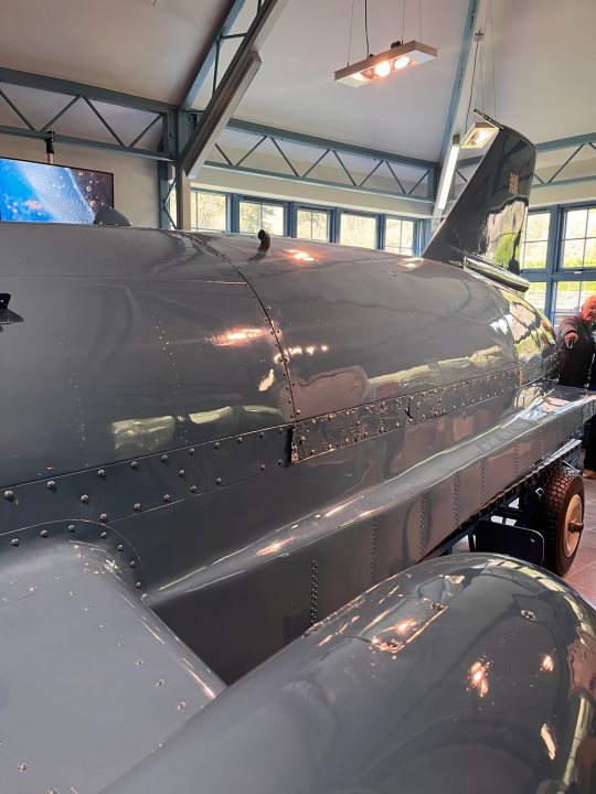 Pistonheads - The image showcases a large, gray airplane model on display. It's exhibited in an indoor setting, possibly a museum or exhibition hall, with white walls and a ceiling visible in the background. There are people present in the space, but they are not the focus of the image. The airplane appears to be an exhibit piece, as indicated by its placement and the overall context of the scene.