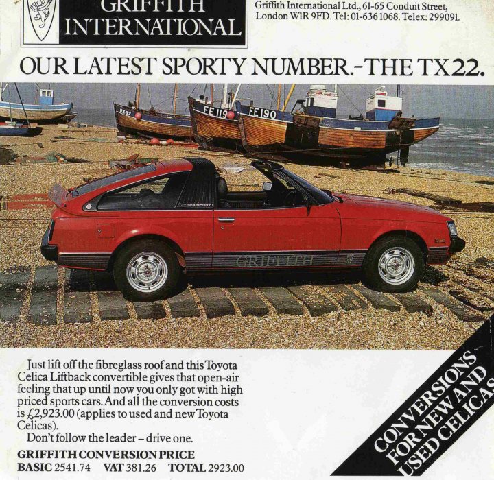 What's this Jap barn find? - Page 1 - Jap Chat - PistonHeads - This image features a classic red Toyota with its top down, displayed prominently on a car dealership lot. The car is centered, and the dealership's lot infrastructure suggests a hard-earned sales status. In the backdrop, several boats and a small body of water are visible, implying a coastal or maritime locale for the dealership. There is text present that hints at the model and the dealership's contact number.