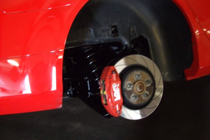 Pistonheads Underseal Waxoyl - The image shows a close-up view of a red car tire, revealing the tire's patina and the inside of the metal wheel rim. The tire is mounted on the rim and appears to be in good condition, with no obvious signs of wear or damage. There is some reflection on the surface of the rim, indicating that the tire is rotating. The metal rim exhibits slight reflections, suggesting it is well-maintained. The rim's hardware connects the wheel to the car, with visible bolts ensuring its secure attachment. The tire tread features a North American-style road pattern, suggesting the car may be intended for driving on North American roads.