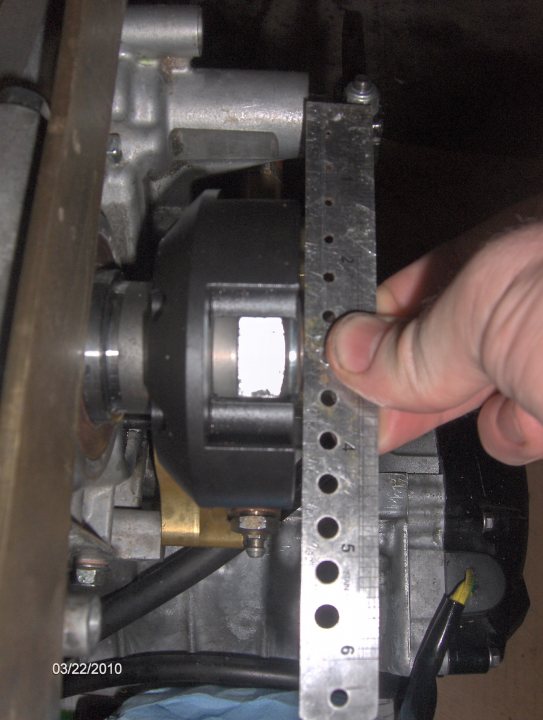 Busa Pistonheads Installation - The image shows a person holding up a ruler to measure a mechanical or electrical component. The ruler measures approximately 5 inches. The object being measured appears to be a component with a rectangular shape and a black or dark red color. The scissor model imprinted on the image is a Walter Scott model possibly of the '03 Heavy Duty' variety. The image seems to have been taken in a setting involving tools and mechanics, as indicated by the presence of the ruler and component. The focus is sharp on the ruler and the component being measured, while other objects and the person remain out of focus, providing a shallow depth of field.