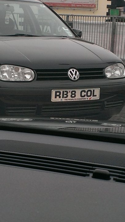 What crappy personalised plates have you seen recently? - Page 238 - General Gassing - PistonHeads - The image captures a black Volkswagen on the road. The front of the car is visible, starring the vehicle's license plate, which stands out with its bold lettering and numbering. The license plate reads "R138 COL," indicating the region of "The People's Champion 4." The car appears to be in motion, driving on a road with other vehicles in the distance. The overall impression is one of a driver or passenger privately enjoying their journey while at the same time indirectly inviting attention or engagement based on the license plate text.