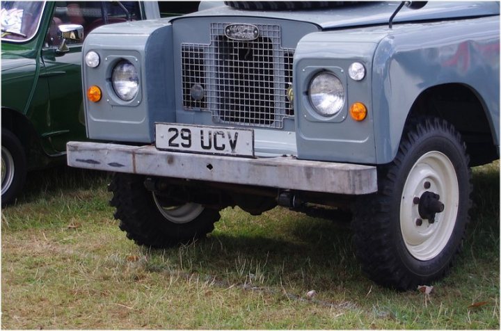 Real Good Number Plates vol 5 - Page 411 - General Gassing - PistonHeads - In the image, a grey Range Rover is parked in a grassy area. The vehicle's license plate reads "29 UCV". In the background, there's a green car parked, and a person is present, although their details are not clear. The vehicles and the person are placed diagonally in the frame from the bottom left to the top right, creating a sense of movement.