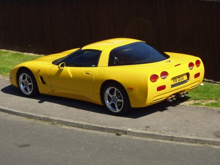 Thoughts Pistonheads - The image captures a vibrant yellow Connault Border sports car parked on the side of a road, angled slightly towards the camera. The sports car is notable for its prominent rear spoiler and four tailpipes, typical of high-performance vehicles, which are neatly arranged in a row. The car is parked next to a black wooden fence, offering a stark contrast to the car's bright yellow color. The curb next to the car is grassy, giving a sense of tranquility to the scene. The image conveys a sense of elegance and excitement, a testament to the thrilling nature of sports cars.