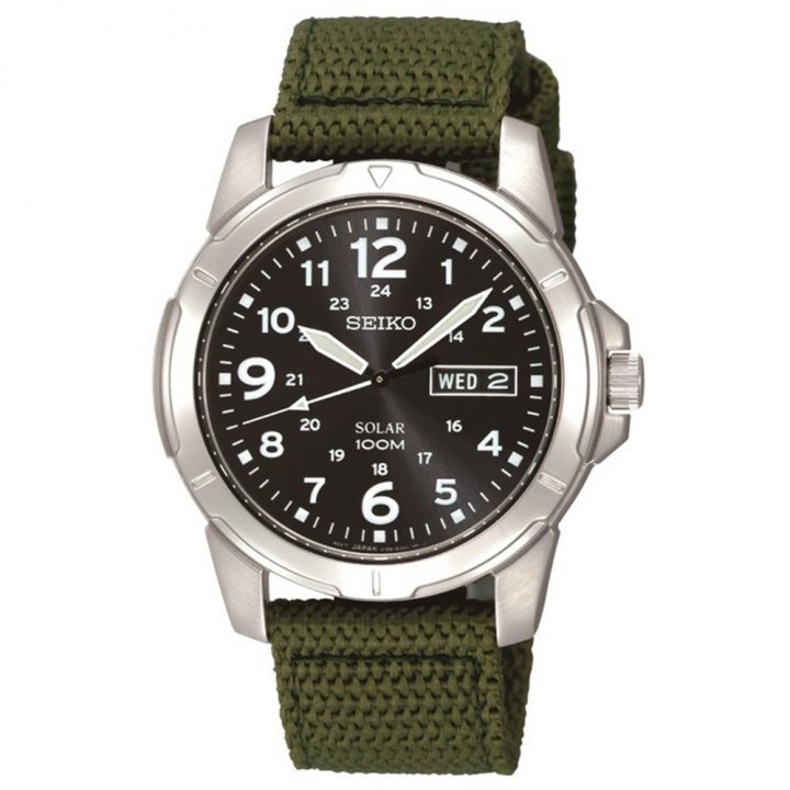 Pistonheads - This image shows a wristwatch with a black and white face, featuring a date window and the Seiko logo. The watch is housed within a silver or steel case. Around the wrist, there is a green fabric strap. The background of the image is not distinctly visible, but it appears to be a simple, neutral backdrop that does not detract from the focus on the watch. There are no visible texts other than the brand name "Seiko" and possibly some watch-related text that may not be legible in this description. The style of the image is product photography with a clear focus on the item to showcase its design and features.