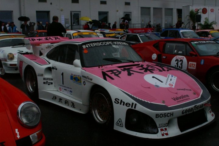 Pistonheads - In the heart of a bustling street, a museum-type building stands as a backdrop for a riot of colors. A historic pink and white Shell interception car from China commands attention, its vinyl wrap gleaming. Nearby, a crowd has gathered, their collective energy adding to the vibrant atmosphere. Their interest is held by the multitude of cars surrounding them. Each car is distinct, bearing the marks of its past - logos of its sponsors, accolades of its performances, and the marks of races won. These cars are more than just vehicles; they are art on wheels.