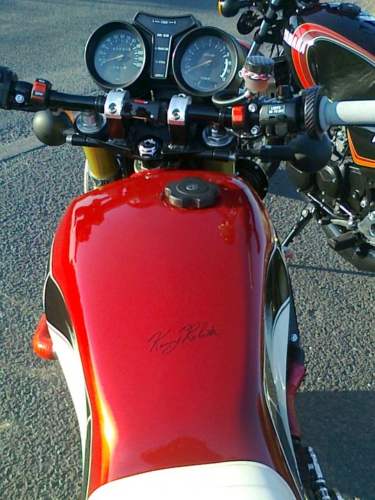 A red motorcycle parked on the side of a road - Pistonheads