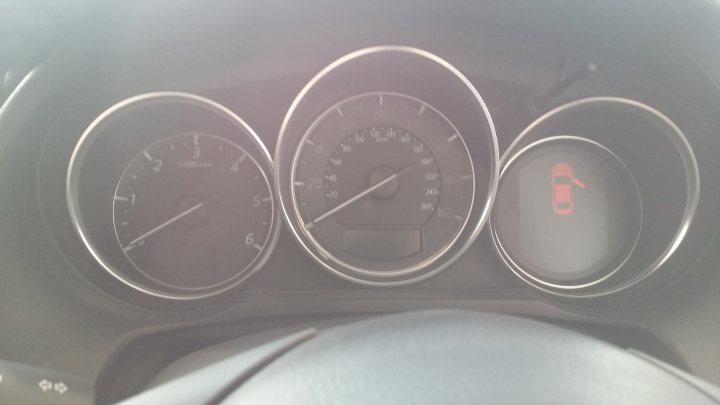 A close up of a clock on a wall - Pistonheads - The image captures a moment inside a vehicle, showing the dashboard and part of the steering wheel. Dominating the scene are three gauges set in a triangular formation. The leftmost gauge is a speedometer, marked from 0 to 120 miles per hour. Adjacent to it, slightly crowded, is a fuel gauge. The fuel gauge levels out just beneath the 50% mark, indicating that the vehicle's tank is half full. To the right, the third gauge displays the temperature, ranging from a minimum of 32 degrees Fahrenheit to a maximum of 160 degrees Fahrenheit. The guages are surrounded by a variety of different colored lights and graphics, each related to different settings or information, but the purpose of these is not clear from the image alone. The steering wheel, with its patterned grip, occupies the foreground of the image.