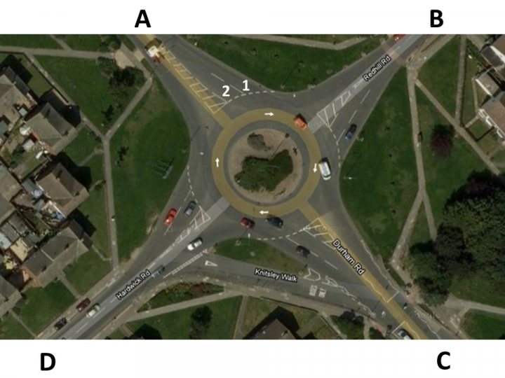 Another roundabout question - Page 1 - Advanced Driving - PistonHeads - The image is an aerial view of a street intersection labeled A, B, and C. It features a large roundabout with multiple lanes and clear lane markings. The intersection is surrounded by a grassy area and neatly divided by white lines. Numerous cars can be seen driving on the roads, and there is a sign indicating "Partrick Road" near the intersection. The layout suggests an organized traffic system with clear lanes for vehicles to navigate.