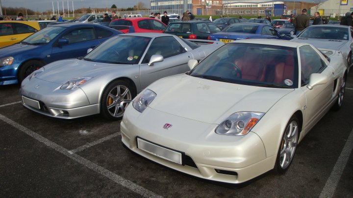 Pistonheads Service Sunday Oxford - The image captures a scene of a parking lot filled with a variety of cars. There's a dense mix of models, colors, and years, indicating a public parking area in a city or town. The foreground is dominated by a mix of silver, blue, and red cars, which are sleek and well-maintained, suggesting a higher-end or city setting. The lighting in the photo is bright, suggesting it might be daytime. The background, while lighter and more open, also contains an assortment of cars parked in neat rows. The presence of multiple cars and the way they are parked suggest that this is a common and busy location.