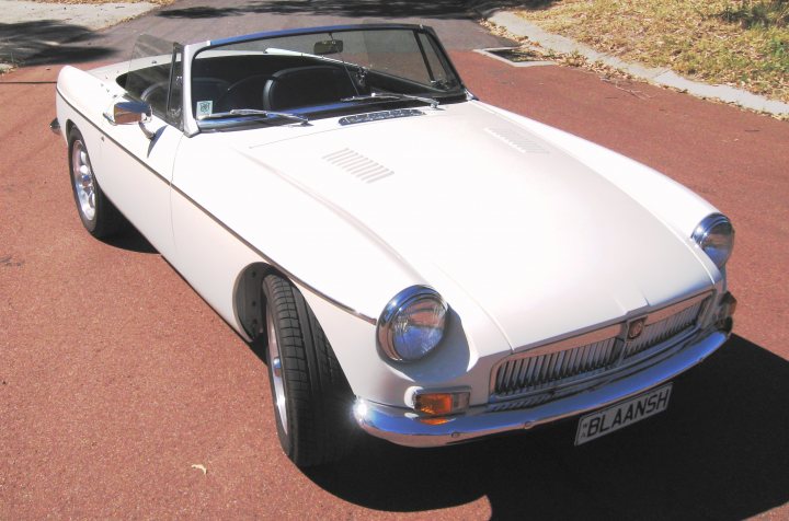 Pistonheads Special Mgb - This is an image of a vintage sports car with a white exterior. The car is positioned on a road, and there is a license plate displayed at the front. The vehicle features a bucket seat design, and the sky can be seen in the background, suggesting the photo might have been taken during the day. The car's design conveys a sense of old-world charm and luxury.