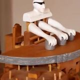 Manually cranked wood toy performs sleight-of-hand magic