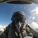 Fighter jet pilot drinking water while flying upside down.